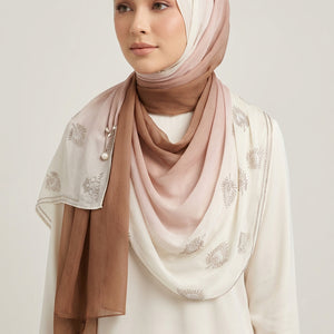 White fabric with floral embroidery draped over a white background