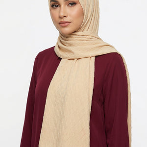 Beige quilted fabric with a swirling pattern