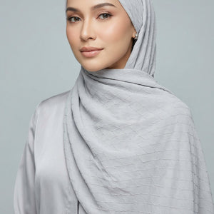 Folded fabric with a subtle pattern on a light gray background
