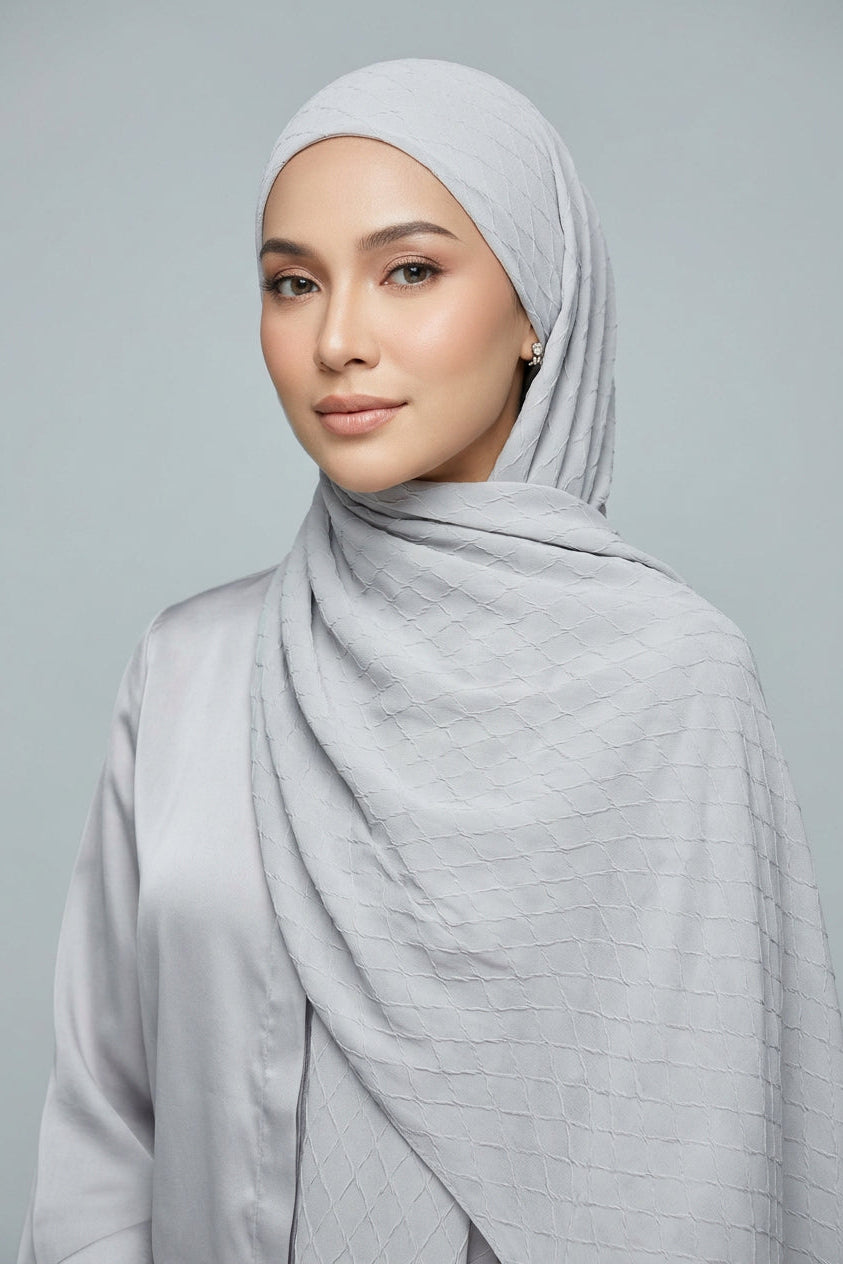 Folded fabric with a subtle pattern on a light gray background