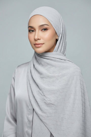 Folded fabric with a subtle pattern on a light gray background