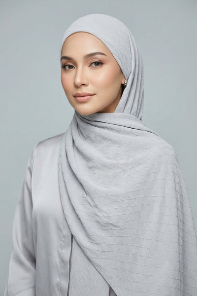 Folded fabric with a subtle pattern on a light gray background