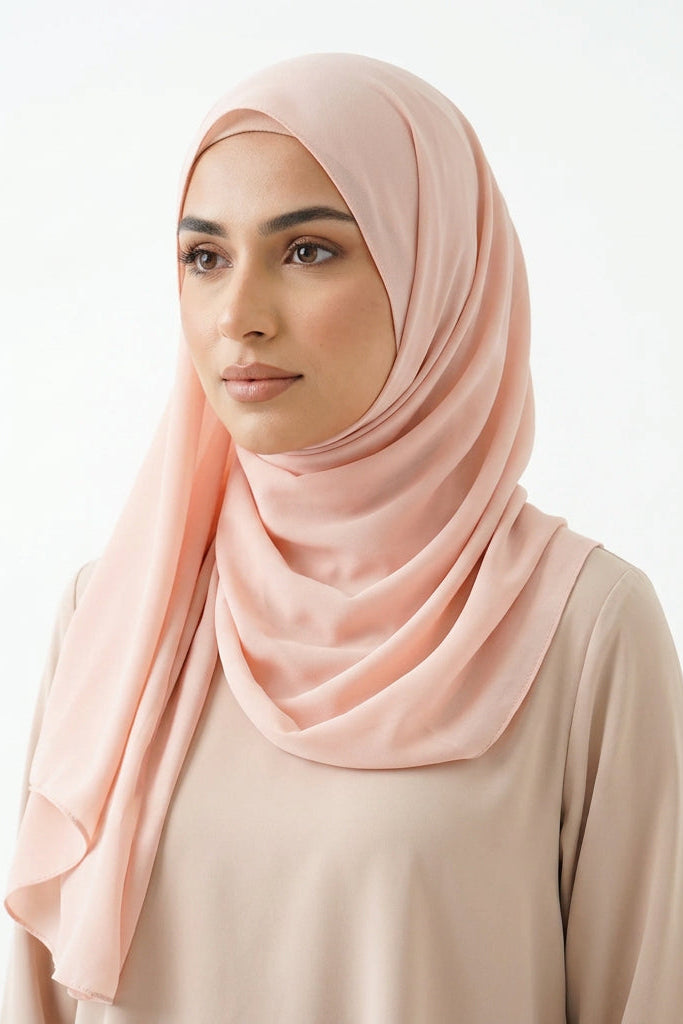 Pink scarf draped over a white surface with a subtle pattern